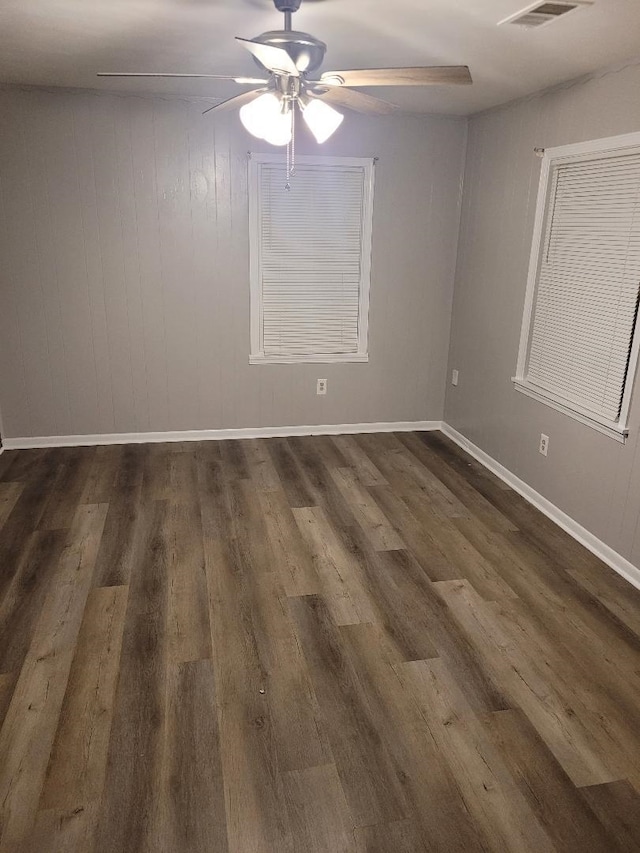 spare room featuring dark wood-type flooring and ceiling fan