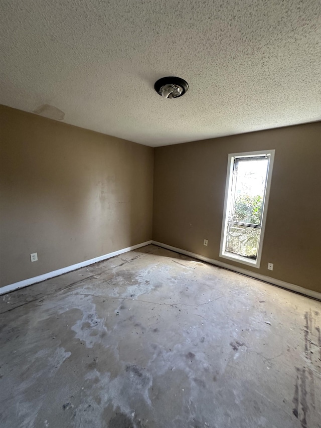 unfurnished room featuring concrete floors and a textured ceiling