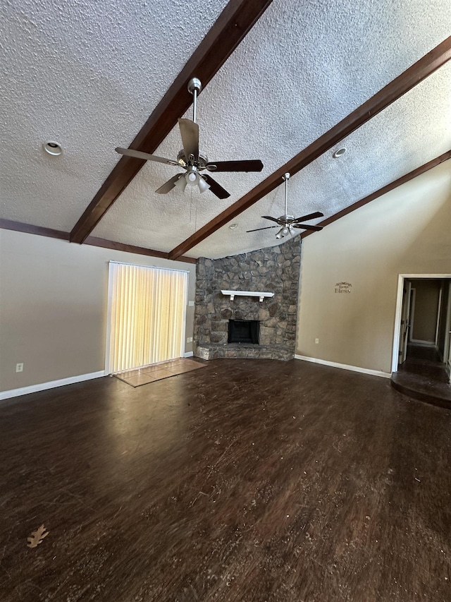 unfurnished living room with hardwood / wood-style flooring, a fireplace, a textured ceiling, and vaulted ceiling with beams