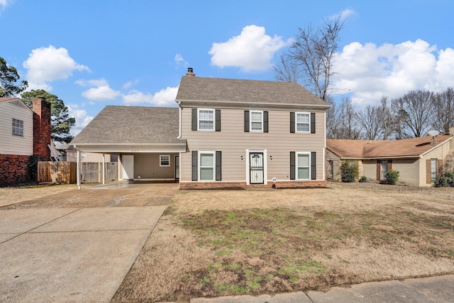 colonial home featuring a carport and a front lawn