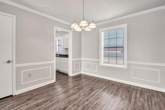 unfurnished dining area featuring crown molding, dark wood-type flooring, sink, and an inviting chandelier