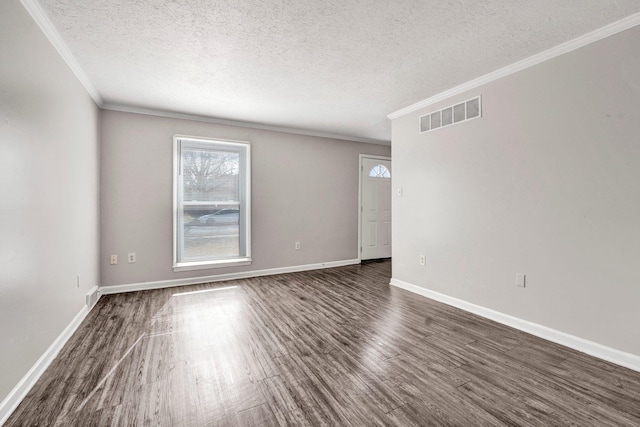 spare room featuring ornamental molding, dark wood-type flooring, and a textured ceiling