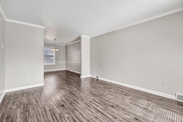 spare room with ornamental molding, dark hardwood / wood-style floors, a chandelier, and a textured ceiling