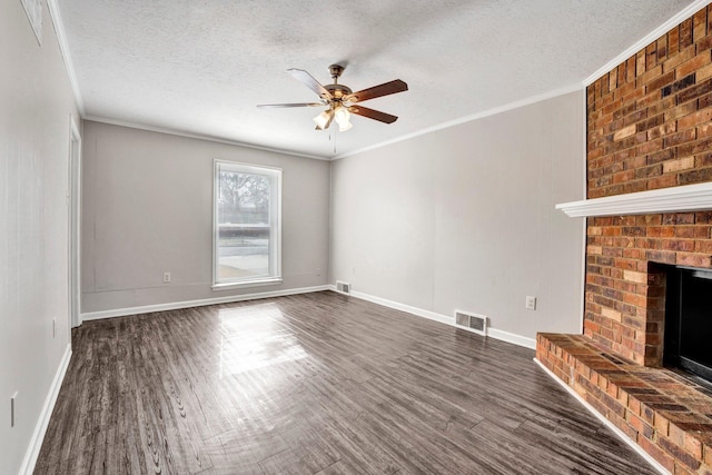 unfurnished living room featuring a brick fireplace, crown molding, dark hardwood / wood-style floors, and a textured ceiling