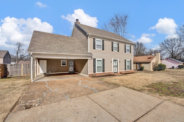 rear view of house featuring a lawn and a carport