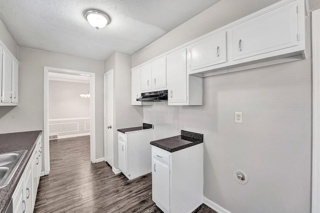 kitchen with dark hardwood / wood-style flooring, sink, a textured ceiling, and white cabinets