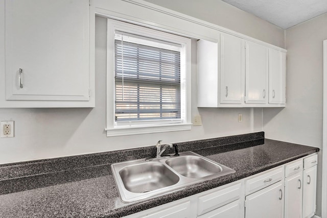 kitchen featuring white cabinetry and sink