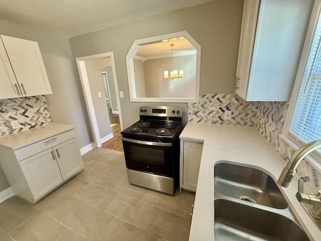 kitchen with hanging light fixtures, white cabinetry, backsplash, and stainless steel electric range