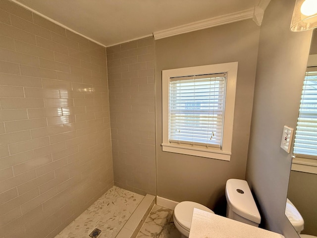 bathroom featuring vanity, crown molding, toilet, and tiled shower