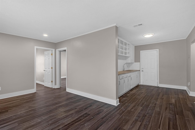 unfurnished room with crown molding, sink, and dark hardwood / wood-style floors