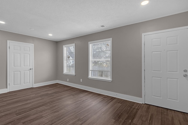 unfurnished room with ornamental molding, dark hardwood / wood-style flooring, and a textured ceiling