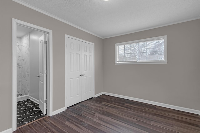 unfurnished bedroom with crown molding, dark hardwood / wood-style flooring, a closet, and a textured ceiling