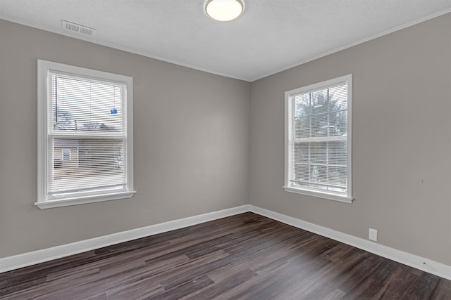 spare room featuring crown molding, a textured ceiling, and dark hardwood / wood-style flooring