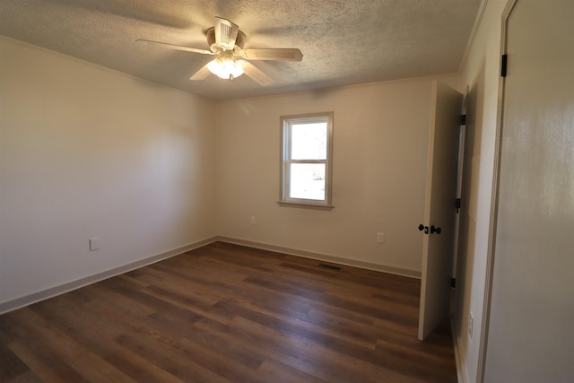 empty room featuring ceiling fan, dark hardwood / wood-style floors, and a textured ceiling