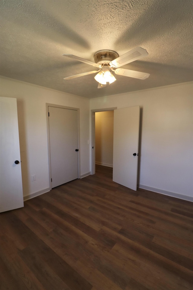 unfurnished bedroom with ceiling fan, dark hardwood / wood-style floors, and a textured ceiling