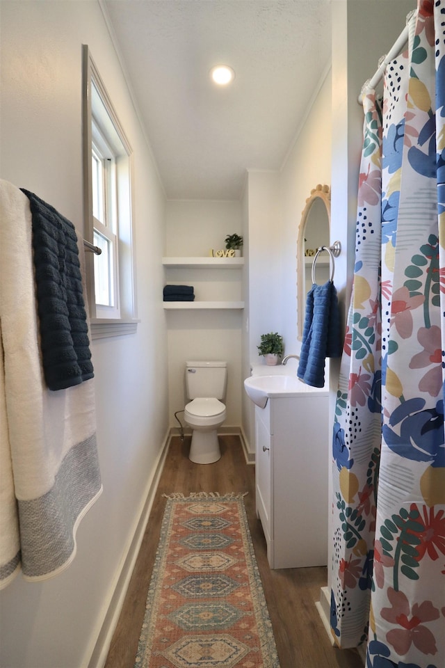 bathroom with crown molding, vanity, toilet, and hardwood / wood-style floors