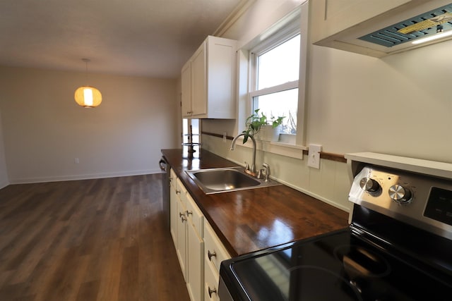 kitchen with sink, white cabinetry, stainless steel range with electric stovetop, wooden counters, and hanging light fixtures