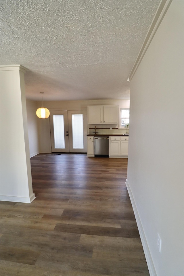 unfurnished living room featuring dark wood-type flooring, french doors, and a textured ceiling