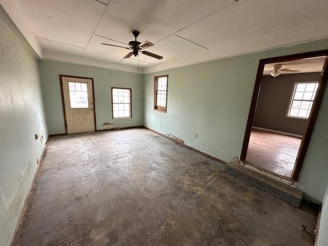 spare room with ceiling fan and concrete floors