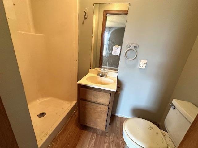 bathroom with vanity, hardwood / wood-style flooring, toilet, and walk in shower