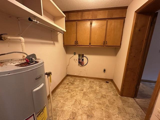 clothes washing area with water heater, electric dryer hookup, cabinets, washer hookup, and a textured ceiling