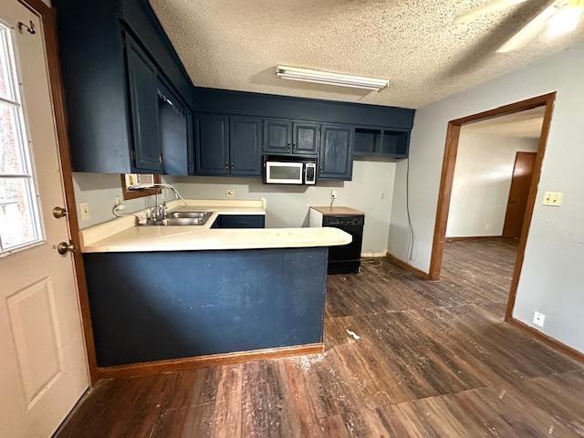 kitchen featuring sink, a textured ceiling, and dark hardwood / wood-style floors