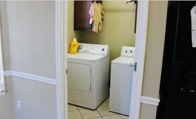 washroom with light tile patterned floors and washing machine and dryer