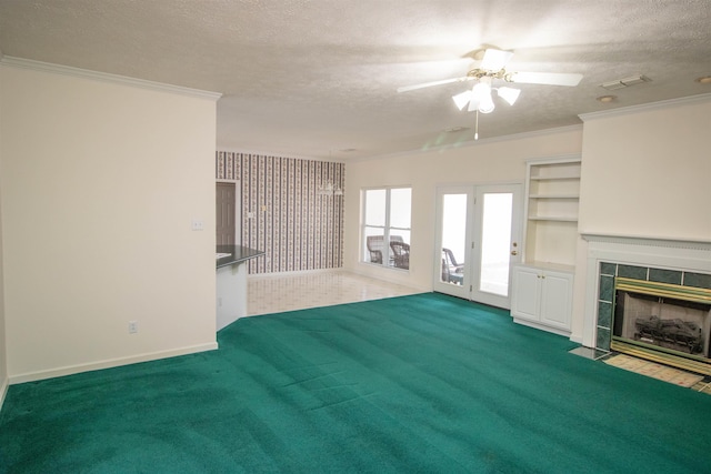 unfurnished living room with a tile fireplace, crown molding, and a textured ceiling