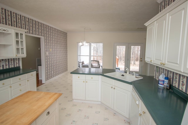 kitchen with sink, ornamental molding, and white cabinets