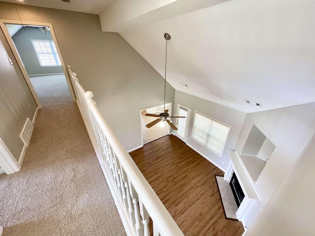 stairway featuring ceiling fan, carpet flooring, and vaulted ceiling