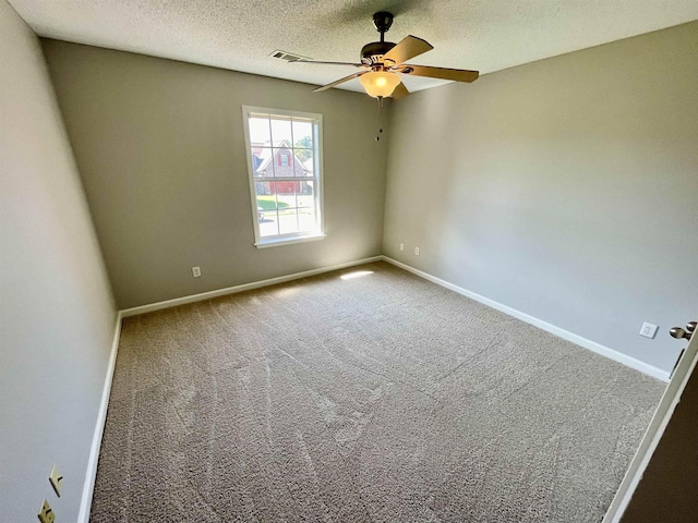 carpeted spare room with ceiling fan and a textured ceiling