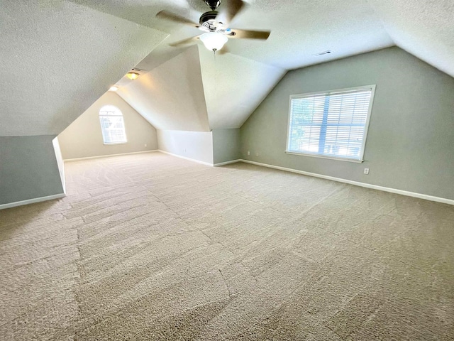 bonus room featuring ceiling fan, vaulted ceiling, a textured ceiling, and carpet flooring