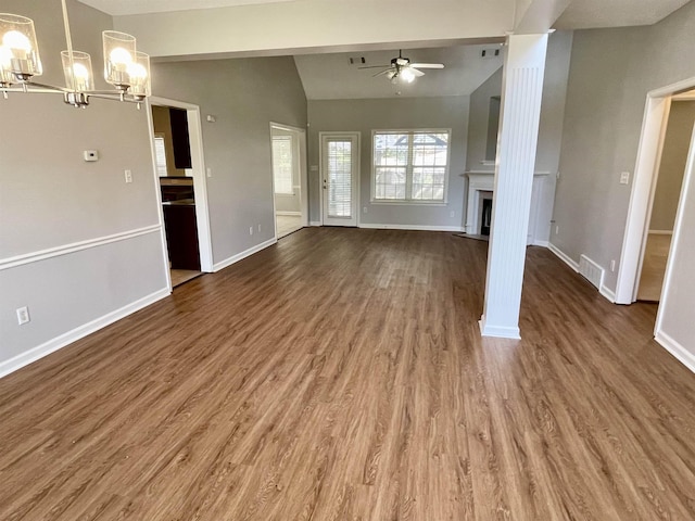 unfurnished living room featuring dark wood-type flooring, lofted ceiling, and ceiling fan with notable chandelier