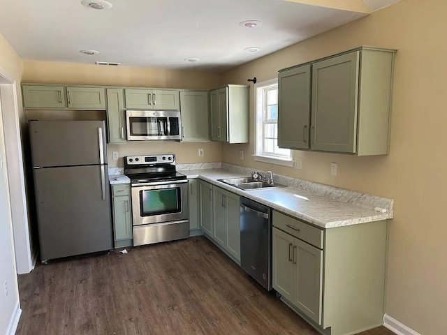 kitchen featuring appliances with stainless steel finishes, dark hardwood / wood-style flooring, and sink