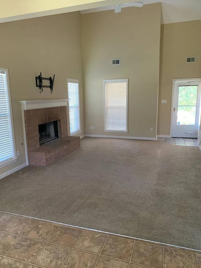 unfurnished living room with a fireplace, carpet floors, high vaulted ceiling, and ceiling fan