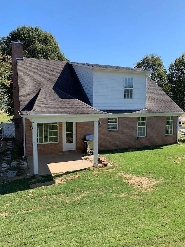 back of house with a patio area and a lawn