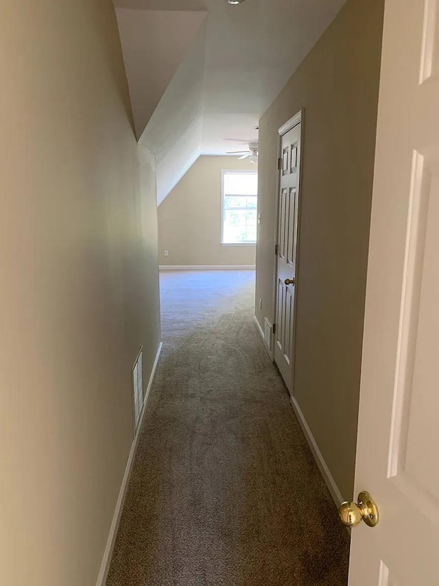 hall with vaulted ceiling and carpet