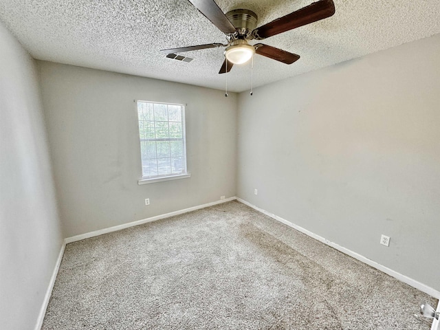 spare room with baseboards, a textured ceiling, visible vents, ceiling fan, and carpet