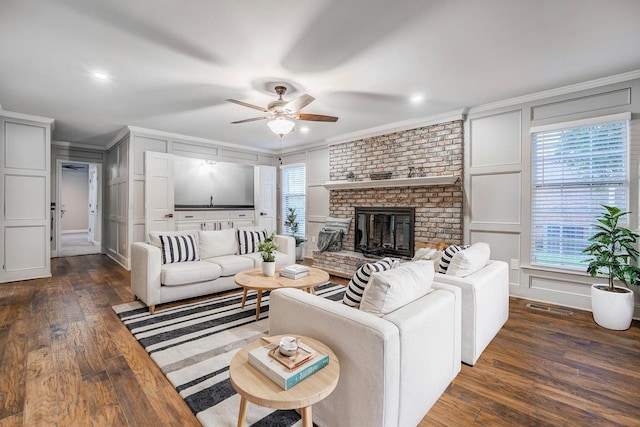 living room with crown molding, plenty of natural light, and dark hardwood / wood-style floors