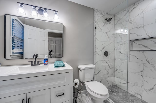 bathroom featuring tiled shower, vanity, and toilet