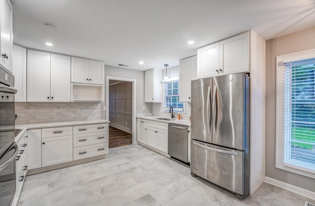 kitchen featuring pendant lighting, plenty of natural light, white cabinets, and appliances with stainless steel finishes