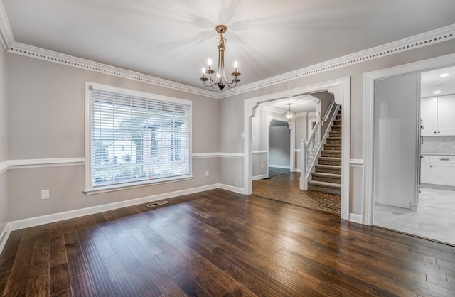 unfurnished dining area featuring an inviting chandelier, dark wood-type flooring, and ornamental molding