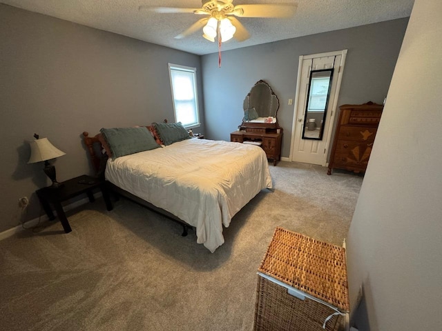 carpeted bedroom featuring ceiling fan and a textured ceiling