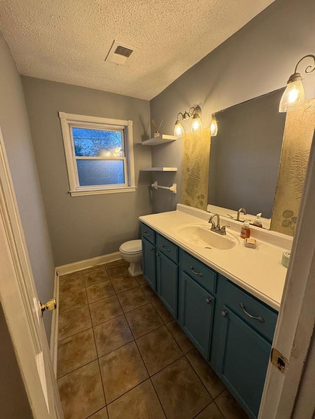 bathroom featuring tile patterned floors, vanity, toilet, and a textured ceiling