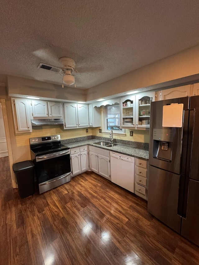 kitchen with dark wood-type flooring, appliances with stainless steel finishes, sink, and white cabinets