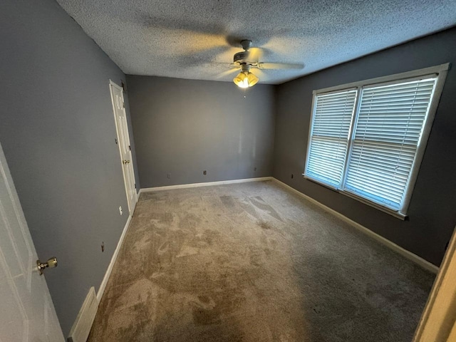 unfurnished room featuring ceiling fan, carpet floors, and a textured ceiling