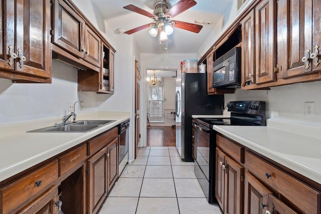 kitchen with sink, light tile patterned floors, ceiling fan with notable chandelier, and black appliances