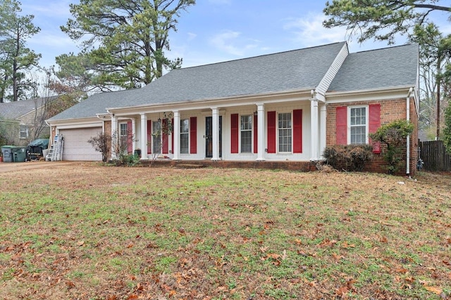 view of front of property featuring a garage, a front yard, and a porch