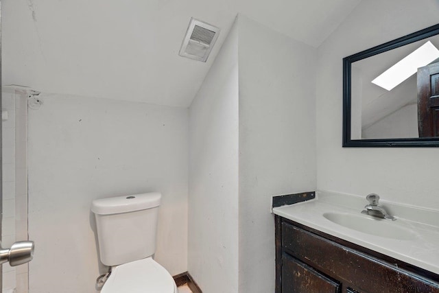 bathroom featuring lofted ceiling, toilet, and vanity