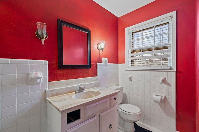 bathroom featuring vanity, toilet, and tile walls